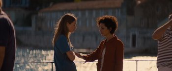 Movie still from “No Limit” (2022), directed by David M. Rosenthal – Two women standing next to each other near a body of water; Medium shot, Over the shoulder angle