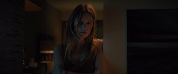 Movie still from “No Limit” (2022), directed by David M. Rosenthal – A woman standing next to a wall in a dark room; Close Up shot, Low angle