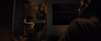 Movie still from “No Limit” (2022), directed by David M. Rosenthal – A woman standing in front of a mirror in a dark room; Medium shot, Low angle