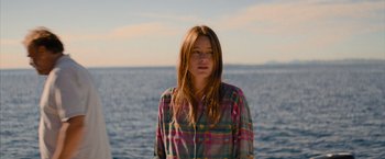 Movie still from “No Limit” (2022), directed by David M. Rosenthal – A woman standing in front of a body of water; Medium shot, Low angle