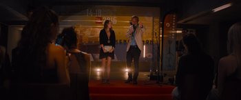 Movie still from “No Limit” (2022), directed by David M. Rosenthal – A man and a woman standing on a stage; Wide shot, Over the shoulder angle