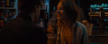 Movie still from “No Limit” (2022), directed by David M. Rosenthal – A woman smiles at a man in a bar; Close Up shot, Over the shoulder angle