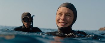 Movie still from “No Limit” (2022), directed by David M. Rosenthal – A woman in a wetsuit in the water; Close Up shot, Over the shoulder angle