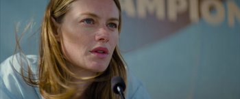 Movie still from “No Limit” (2022), directed by David M. Rosenthal – A person speaking at a microphone; Close Up shot, Over the shoulder angle