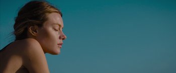 Movie still from “No Limit” (2022), directed by David M. Rosenthal – A beautiful young woman with a blue sky in the background; Close Up shot, Low angle