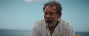Movie still from “No Limit” (2022), directed by David M. Rosenthal – An older man with a beard and a white shirt; Close Up shot, Over the shoulder angle