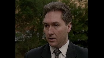 Movie still from “No Mercy, No Remorse” (2022), directed by Terry Carlyon – A person wearing a suit and tie; Close Up shot, Low angle
