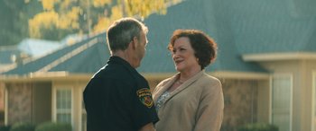 Movie still from “No One Will Save You” (2023), directed by Brian Duffield – A police officer talking to an older woman outside; Medium shot, Over the shoulder angle