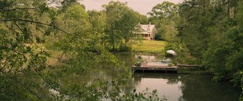 Movie still from “No One Will Save You” (2023), directed by Brian Duffield – A house sitting on the edge of a lake; Extreme Wide shot, High angle
