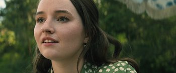 Movie still from “No One Will Save You” (2023), directed by Brian Duffield – A woman's face in a green dress; Close Up shot, Over the shoulder angle