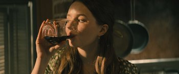 Movie still from “No One Will Save You” (2023), directed by Brian Duffield – A woman drinking a glass of wine from a glass; Close Up shot, Over the shoulder angle