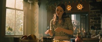 Movie still from “No One Will Save You” (2023), directed by Brian Duffield – A woman in a kitchen preparing food with a knife; Medium shot, Over the shoulder angle