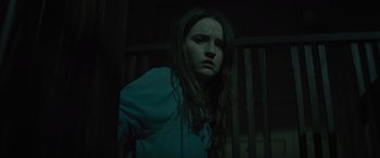 Movie still from “No One Will Save You” (2023), directed by Brian Duffield – A woman standing in the dark with her eyes wide open; Medium shot, Low angle