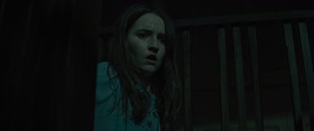 Movie still from “No One Will Save You” (2023), directed by Brian Duffield – A young girl with long dark hair stares into the camera; Close Up shot, Low angle