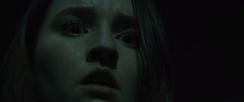 Movie still from “No One Will Save You” (2023), directed by Brian Duffield – A woman's face in the dark; Close Up shot, Low angle