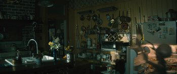 Movie still from “No One Will Save You” (2023), directed by Brian Duffield – A kitchen filled with pots and pans hanging on the wall; Wide shot, High angle