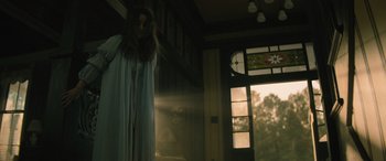 Movie still from “No One Will Save You” (2023), directed by Brian Duffield – A woman standing in front of an open door; Medium shot, Low angle