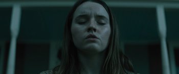 Movie still from “No One Will Save You” (2023), directed by Brian Duffield – A woman with her eyes closed in a dark room; Close Up shot, Low angle