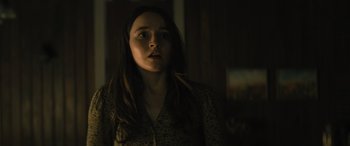 Movie still from “No One Will Save You” (2023), directed by Brian Duffield – A woman with long dark hair stares into the distance; Close Up shot, Over the shoulder angle