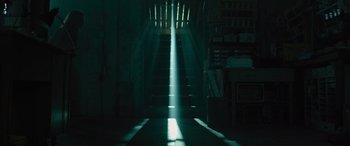 Movie still from “No One Will Save You” (2023), directed by Brian Duffield – A light shining down on the stairs in a room; Extreme Wide shot, Low angle
