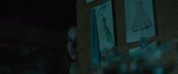 Movie still from “No One Will Save You” (2023), directed by Brian Duffield – A woman standing in front of a drawing of a dress; Close Up shot, Over the shoulder angle