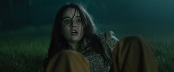 Movie still from “No One Will Save You” (2023), directed by Brian Duffield – A woman with long black hair is looking at the camera; Close Up shot, Low angle