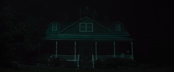 Movie still from “No One Will Save You” (2023), directed by Brian Duffield – A house that has a skeleton on top of the roof; Extreme Wide shot, Low angle