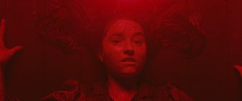 Movie still from “No One Will Save You” (2023), directed by Brian Duffield – A woman with a red light on her head; Close Up shot, Overhead angle