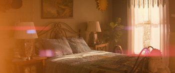 Movie still from “No One Will Save You” (2023), directed by Brian Duffield – A girl laying on a bed in a bedroom; Wide shot, High angle