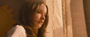 Movie still from “No One Will Save You” (2023), directed by Brian Duffield – A young woman with long brown hair looking at the camera; Close Up shot, Low angle