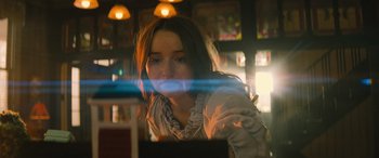 Movie still from “No One Will Save You” (2023), directed by Brian Duffield – A woman sitting in front of a computer monitor; Close Up shot, Over the shoulder angle