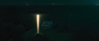 Movie still from “No One Will Save You” (2023), directed by Brian Duffield – A light shining on a house in the dark; Extreme Wide shot, Low angle