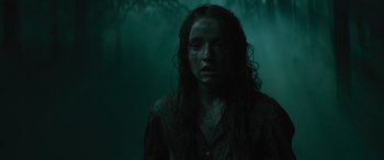 Movie still from “No One Will Save You” (2023), directed by Brian Duffield – A person with long hair and a dark shirt; Medium shot, Low angle