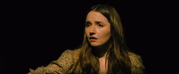 Movie still from “No One Will Save You” (2023), directed by Brian Duffield – A woman with long brown hair is looking at the camera; Close Up shot, High angle