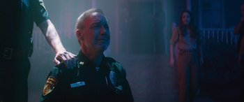 Movie still from “No One Will Save You” (2023), directed by Brian Duffield – A man in a police uniform looking up at the sky; Close Up shot, Low angle