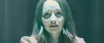 Movie still from “No One Will Save You” (2023), directed by Brian Duffield – A woman with white makeup on her face; Close Up shot, High angle
