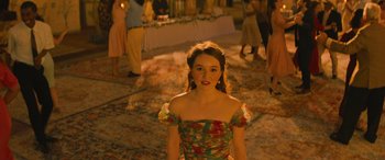 Movie still from “No One Will Save You” (2023), directed by Brian Duffield – A woman in a floral dress standing in front of a crowd; Medium shot, Over the shoulder angle