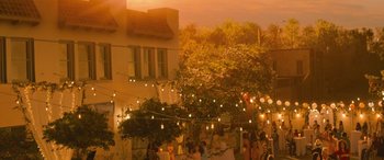 Movie still from “No One Will Save You” (2023), directed by Brian Duffield – A group of people standing under a string of lights; Extreme Wide shot, High angle