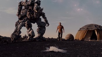 Movie still from “Noah” (2014), directed by Darren Aronofsky – A man standing in front of a giant rock monster; Wide shot, Low angle