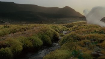 Movie still from “Noah” (2014), directed by Darren Aronofsky – A small stream running through a lush green field; Extreme Wide shot, High angle