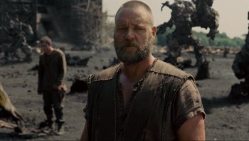 Movie still from “Noah” (2014), directed by Darren Aronofsky – A man with a goatee is standing in the dirt; Medium shot, Over the shoulder angle