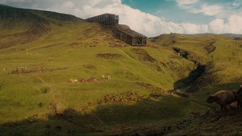 Movie still from “Noah” (2014), directed by Darren Aronofsky – An image of an image of a hill with a wooden structure on top of it; Extreme Wide shot, High angle