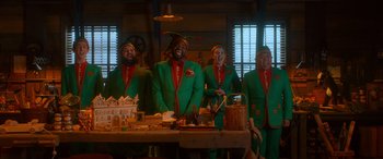 Movie still from “Noelle” (2019), directed by Marc Lawrence – A group of people dressed in green and red costumes; Wide shot, Low angle