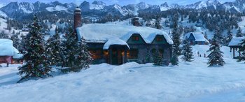 Movie still from “Noelle” (2019), directed by Marc Lawrence – A snowy scene of a house with trees and mountains in the background; Extreme Wide shot, High angle