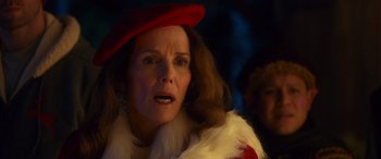 Movie still from “Noelle” (2019), directed by Marc Lawrence – An older woman wearing a red hat and a fur coat; Close Up shot, Over the shoulder angle
