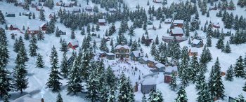 Movie still from “Noelle” (2019), directed by Marc Lawrence – An aerial view of a snow - covered town with lots of trees; Extreme Wide shot, High angle