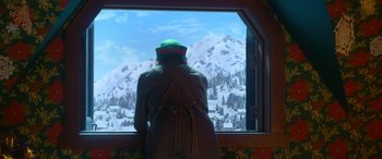 Movie still from “Noelle” (2019), directed by Marc Lawrence – A person standing in front of a window looking out at a snowy mountain; Medium shot, Over the shoulder angle