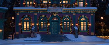 Movie still from “Noelle” (2019), directed by Marc Lawrence – The town hall is lit up at night; Extreme Wide shot, Low angle