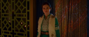 Movie still from “Noelle” (2019), directed by Marc Lawrence – A woman in a green dress and a white fur vest; Medium shot, Over the shoulder angle