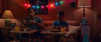Movie still from “Noelle” (2019), directed by Marc Lawrence – Two men sitting at a table eating food; Medium shot, Over the shoulder angle